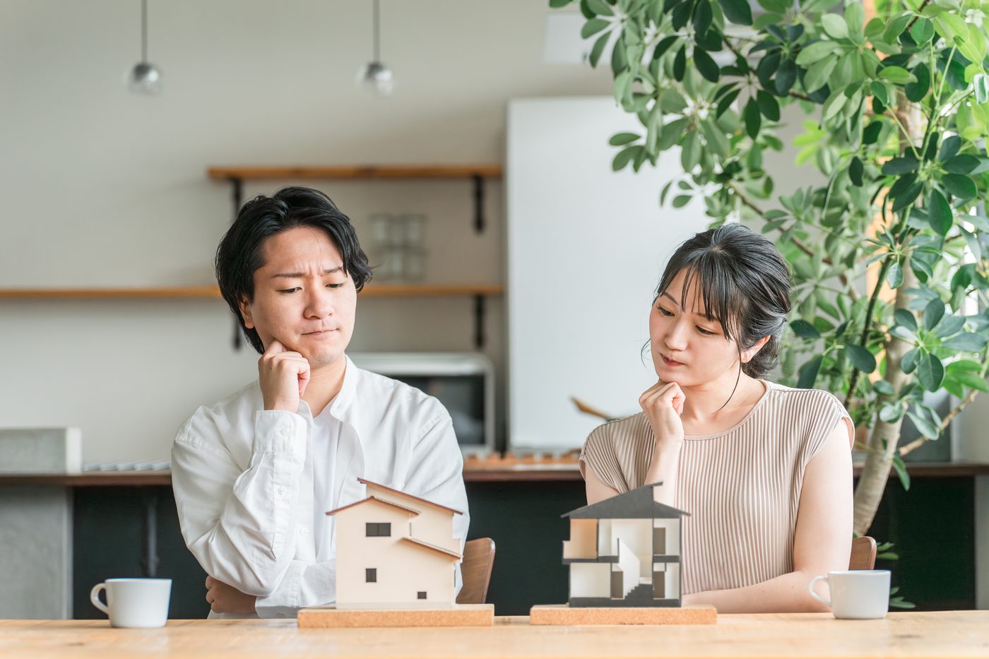 2軒の家の模型を前に考えるご夫婦