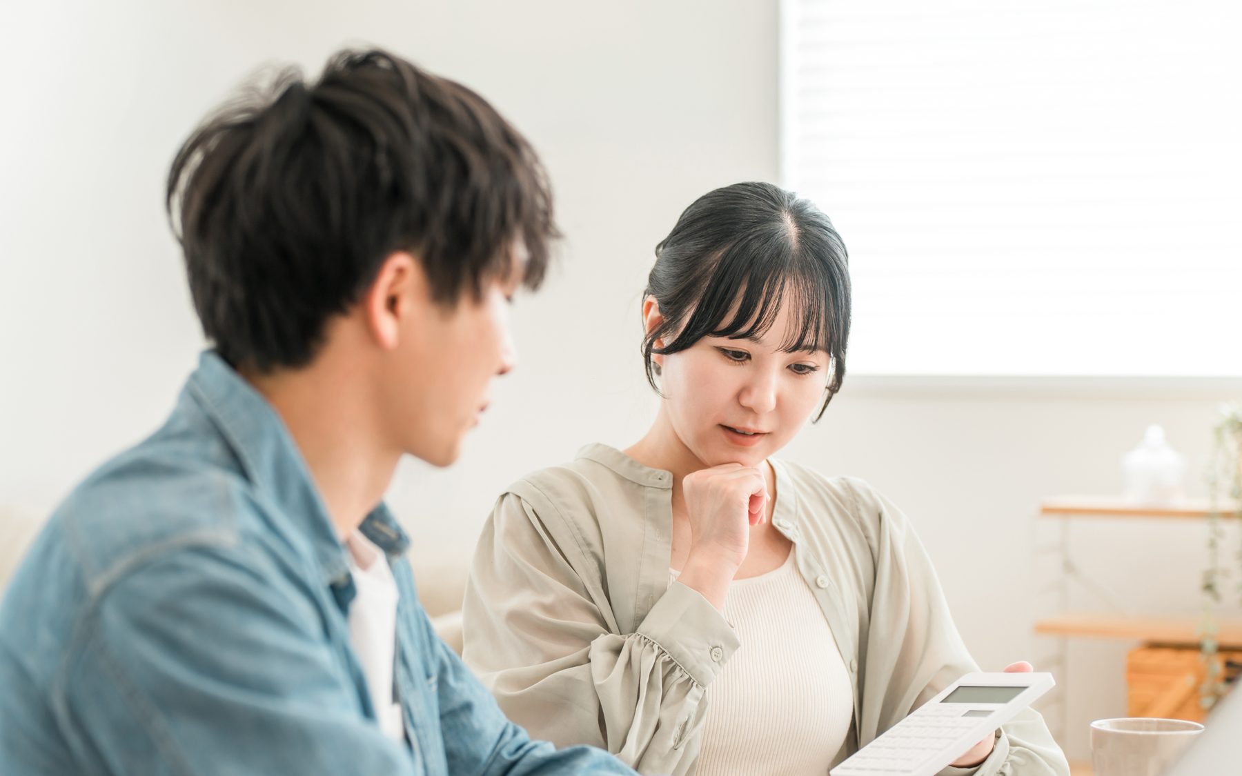 電卓を手に家づくりの費用を考えるご夫婦